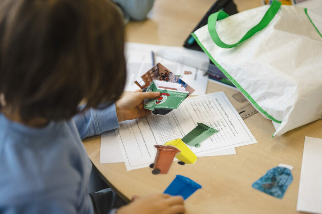 enfants en train de choisir des objets en papier pour un jeu